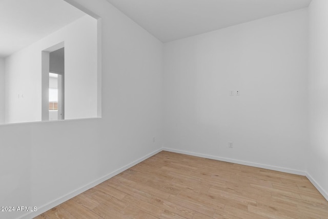 empty room featuring baseboards and light wood finished floors