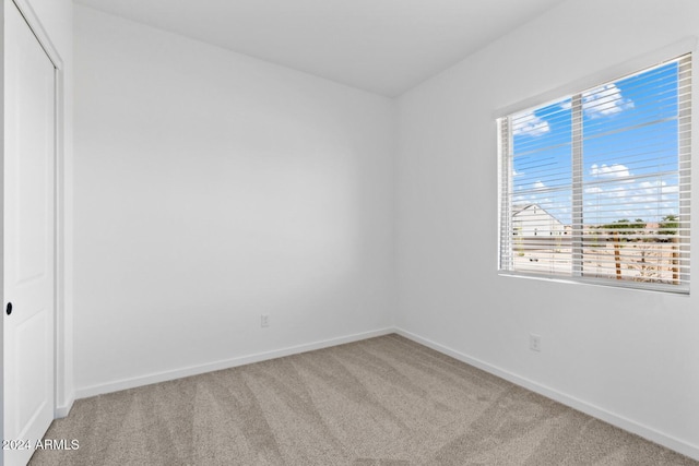 unfurnished room with carpet floors and baseboards