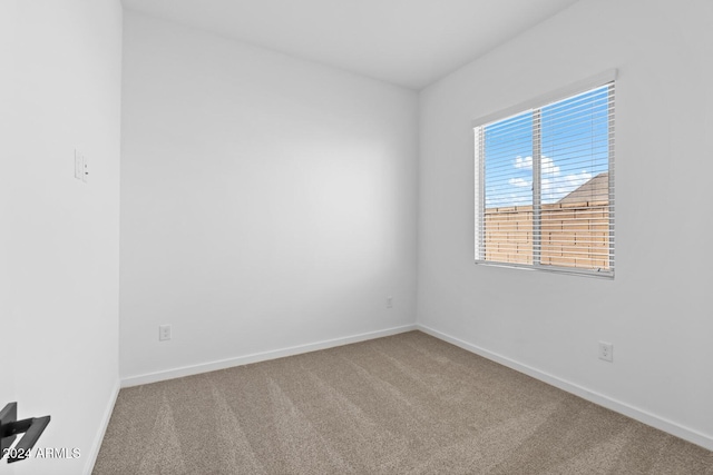 carpeted empty room with baseboards