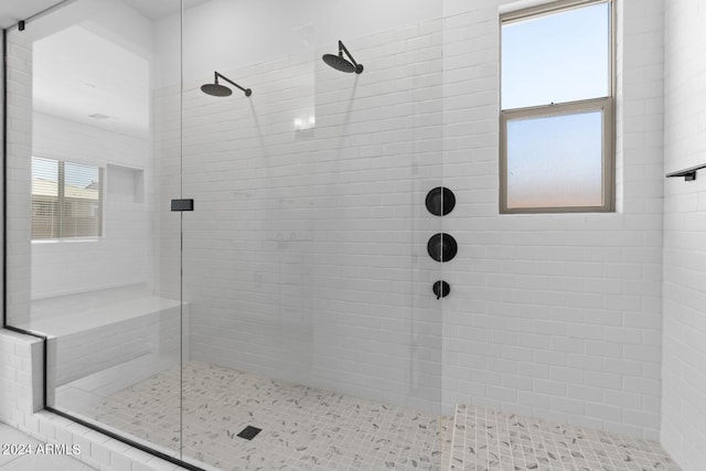 bathroom featuring a tile shower and a wealth of natural light