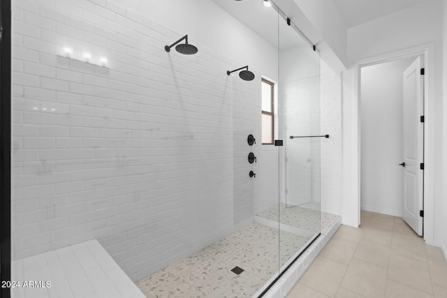 bathroom with a tile shower and tile patterned floors