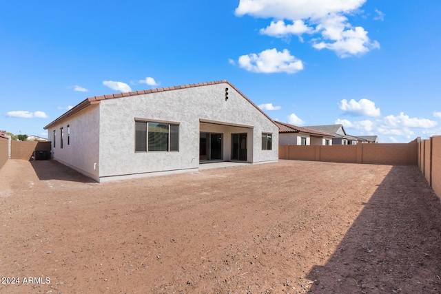 rear view of property with a fenced backyard and stucco siding