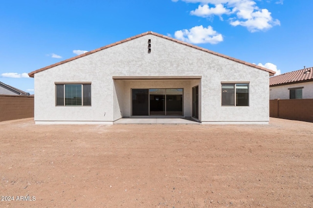 rear view of property featuring fence and stucco siding