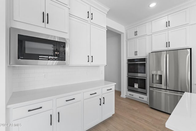 kitchen featuring light wood-type flooring, white cabinetry, appliances with stainless steel finishes, and light countertops