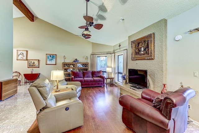 living room featuring ceiling fan, beam ceiling, wood-type flooring, high vaulted ceiling, and a barn door