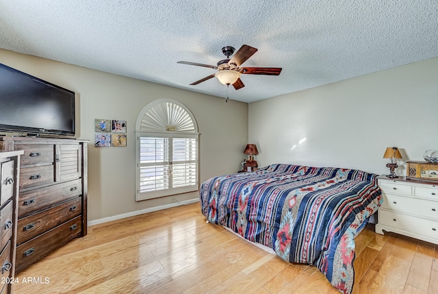 bedroom featuring a textured ceiling, light hardwood / wood-style floors, and ceiling fan