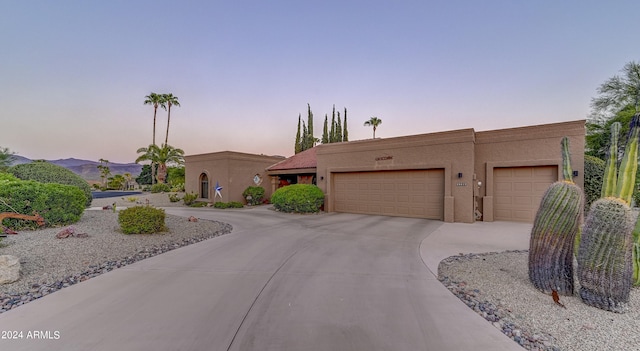 pueblo revival-style home with a mountain view and a garage