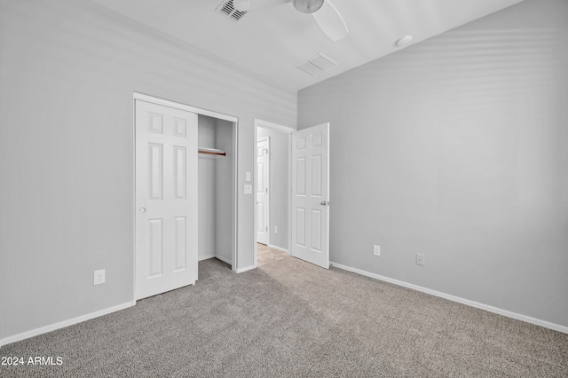 unfurnished bedroom with ceiling fan, light colored carpet, and a closet