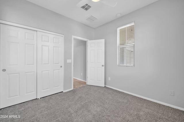 unfurnished bedroom with ceiling fan, a closet, and carpet