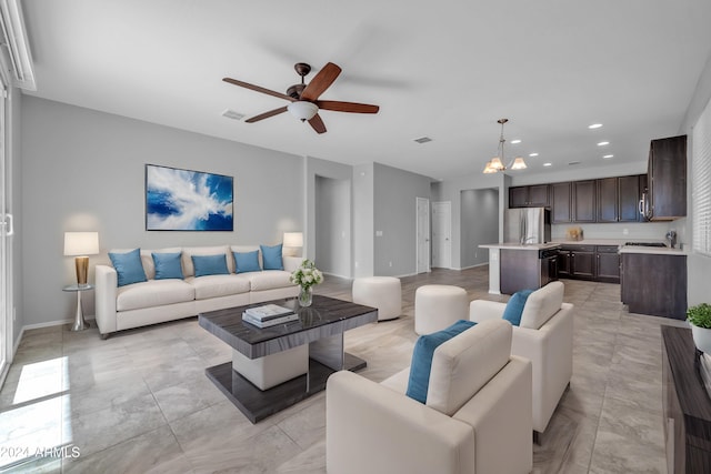 living room with ceiling fan with notable chandelier