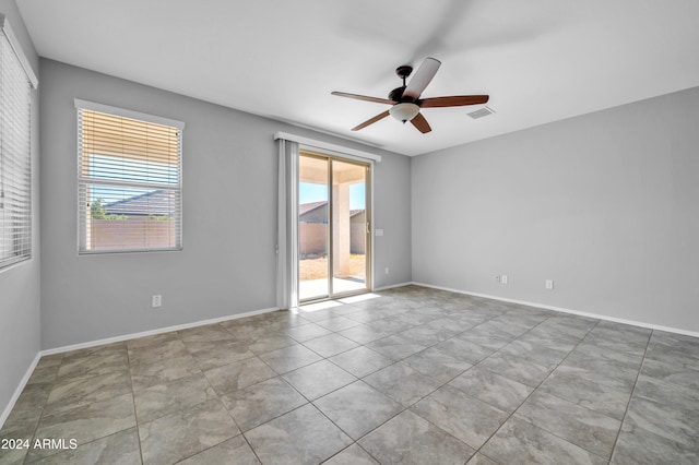 unfurnished room with ceiling fan, light tile patterned floors, and a healthy amount of sunlight