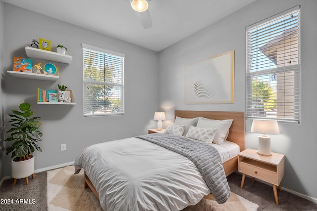 carpeted bedroom featuring multiple windows and ceiling fan