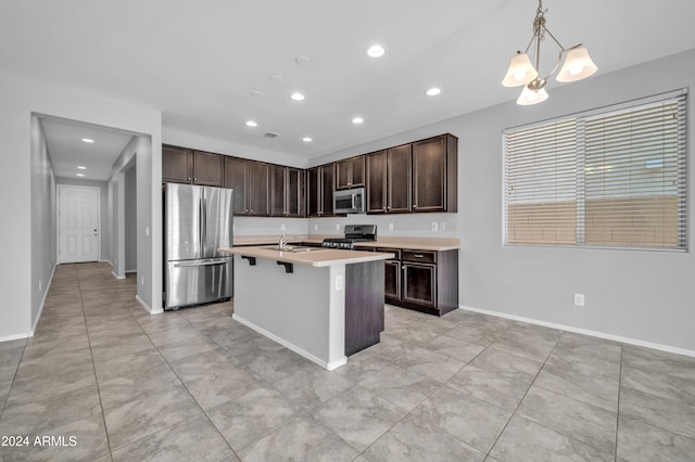 kitchen with a kitchen breakfast bar, an island with sink, pendant lighting, dark brown cabinets, and appliances with stainless steel finishes