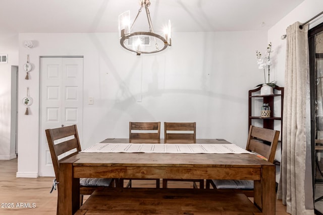 4950 N Miller Rd Unit 200, Scottsdale, AZ 85251 - dining area with a notable chandelier, baseboards, visible vents, and wood finished floors