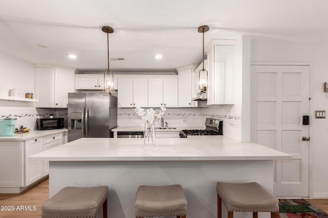 4950 N Miller Rd Unit 200, Scottsdale, AZ 85251 - kitchen with decorative backsplash, a breakfast bar, a peninsula, and stainless steel appliances