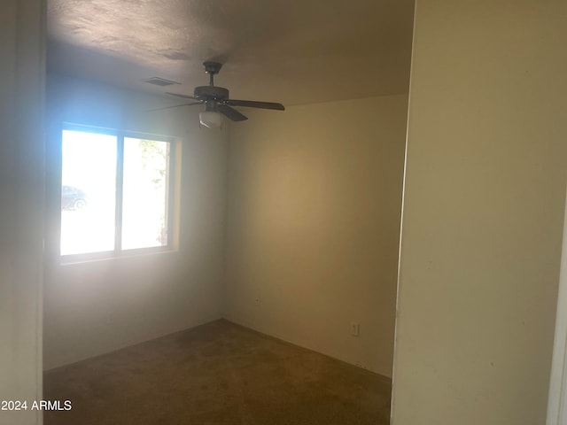 empty room with carpet flooring, a textured ceiling, and ceiling fan