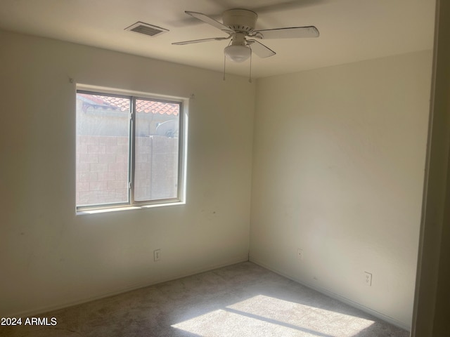 spare room featuring ceiling fan and light colored carpet