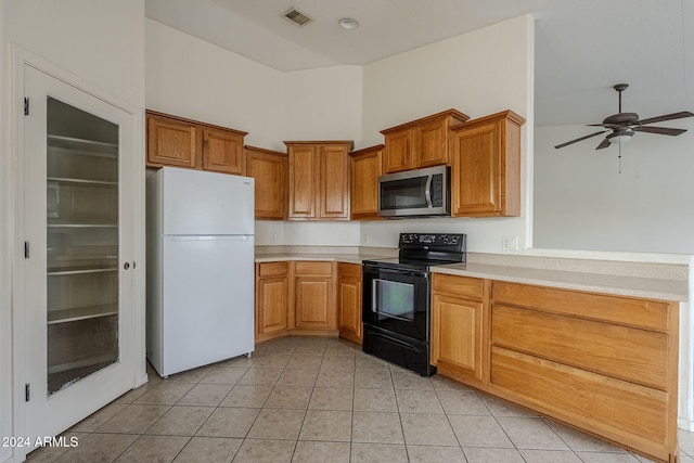 kitchen featuring black electric range oven, white refrigerator, ceiling fan, a towering ceiling, and light tile patterned flooring