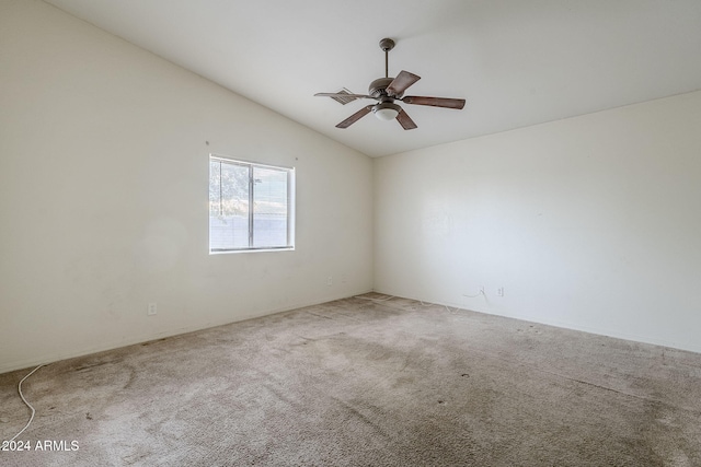 carpeted empty room with vaulted ceiling and ceiling fan