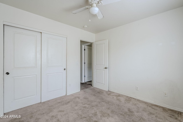 unfurnished bedroom featuring ceiling fan, light carpet, and a closet