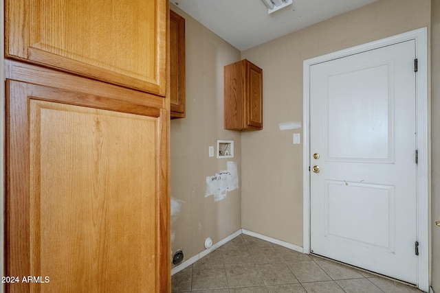 laundry area featuring hookup for a washing machine, light tile patterned floors, and cabinets