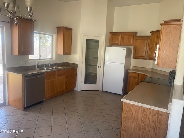 kitchen featuring stove, white refrigerator, sink, stainless steel dishwasher, and a chandelier