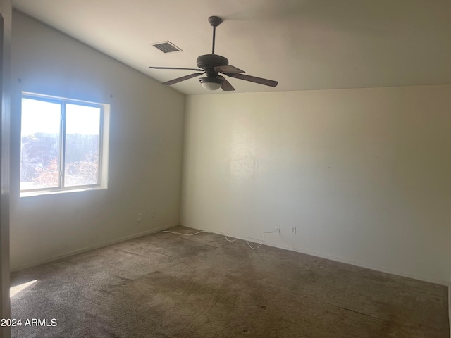 spare room featuring carpet flooring, vaulted ceiling, and ceiling fan