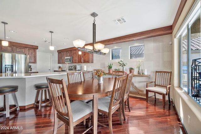 dining space featuring dark hardwood / wood-style floors, a healthy amount of sunlight, and a notable chandelier