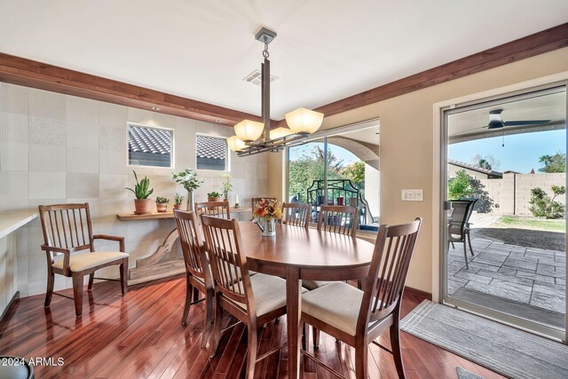 dining area with a chandelier, hardwood / wood-style flooring, and tile walls