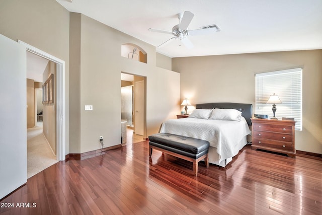 bedroom with ensuite bath, high vaulted ceiling, ceiling fan, and hardwood / wood-style floors