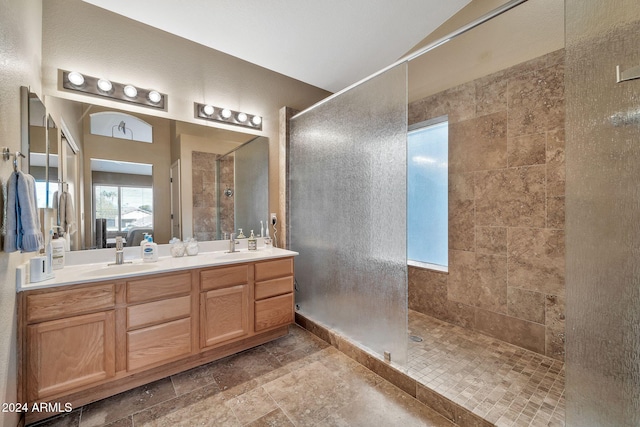 bathroom featuring tiled shower and vanity