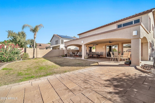 rear view of property featuring a patio, ceiling fan, and a lawn