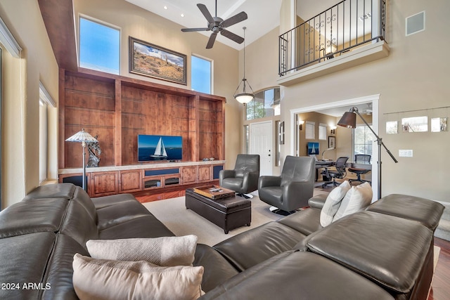 living room featuring hardwood / wood-style flooring, high vaulted ceiling, and ceiling fan