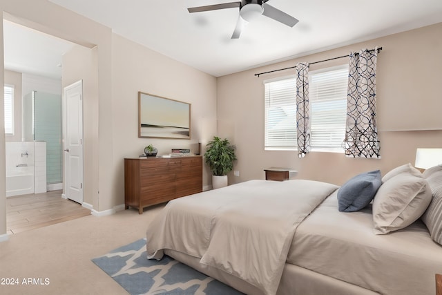 carpeted bedroom with ceiling fan and ensuite bathroom