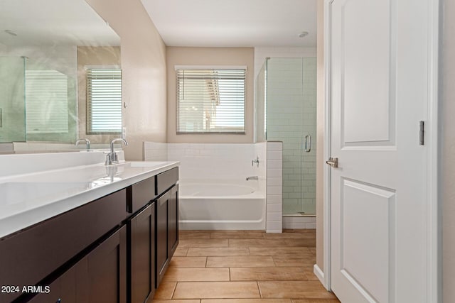 bathroom with vanity and shower with separate bathtub