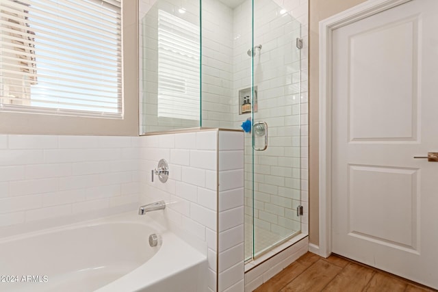 bathroom featuring hardwood / wood-style flooring and plus walk in shower