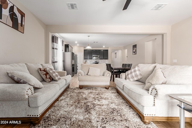 living room featuring wood-type flooring and ceiling fan