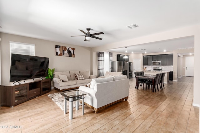 living room featuring ceiling fan and light wood-type flooring