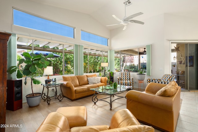 living room with high vaulted ceiling, ceiling fan, and light wood-type flooring