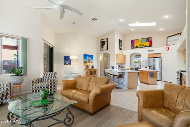 tiled living room with high vaulted ceiling and ceiling fan