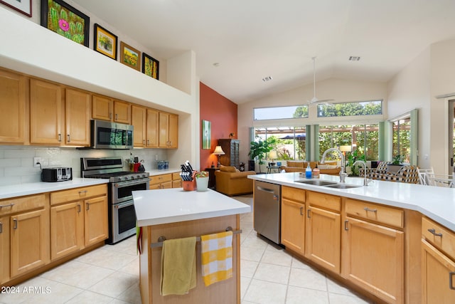 kitchen with light tile floors, sink, tasteful backsplash, stainless steel appliances, and a kitchen island with sink