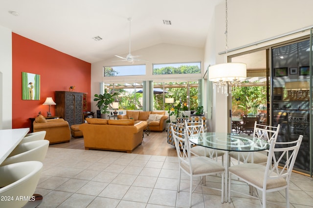 tiled dining room featuring ceiling fan with notable chandelier and high vaulted ceiling