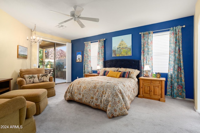 carpeted bedroom featuring ceiling fan with notable chandelier and access to outside