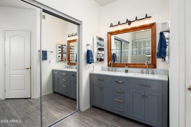 bathroom featuring hardwood / wood-style flooring and dual vanity