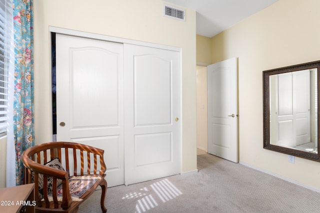 bedroom featuring a crib, light colored carpet, and a closet