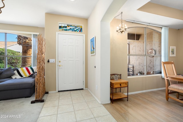 foyer entrance with light tile flooring and a chandelier