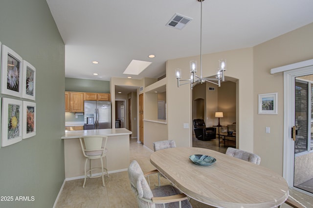 dining room with a chandelier and a skylight