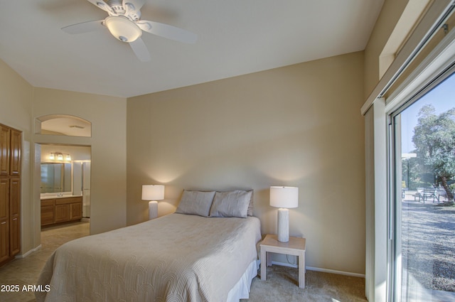 carpeted bedroom with ceiling fan and ensuite bath