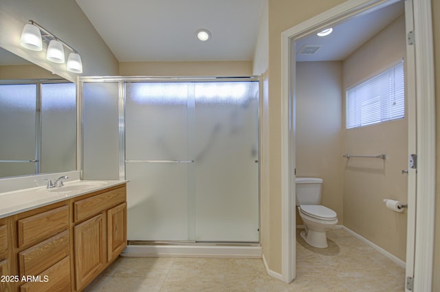 bathroom featuring walk in shower, vanity, toilet, and tile patterned flooring