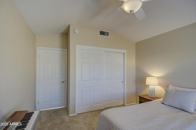 bedroom featuring vaulted ceiling, light colored carpet, ceiling fan, and a closet